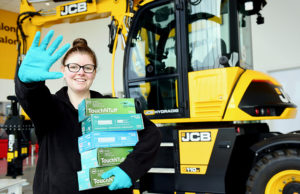 CB customer service provider Jess Mason at JCB World Parts Centre with gloves that are to be donated to the NHS
